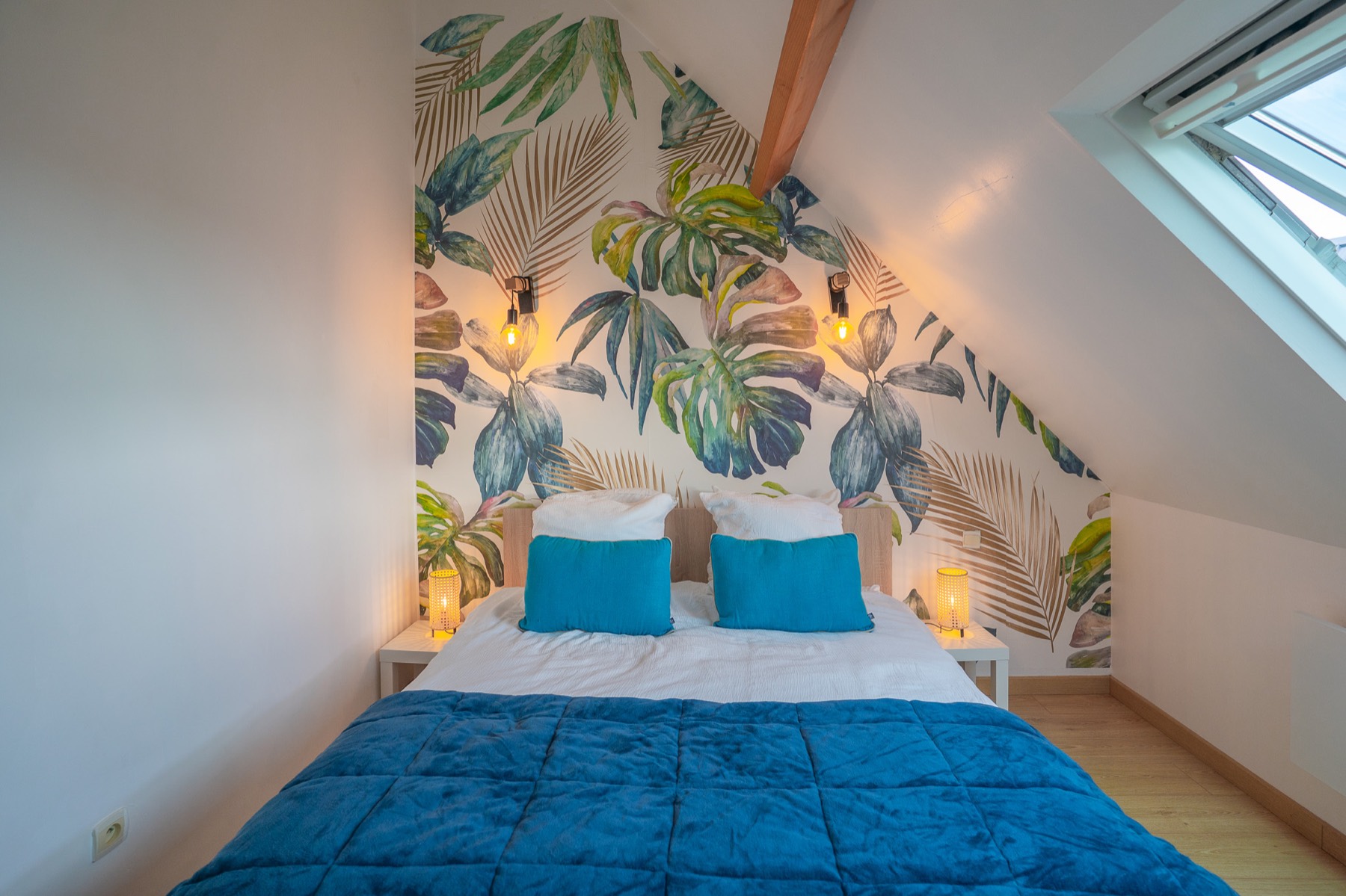 Chambre avec papier peint végétal et lit double